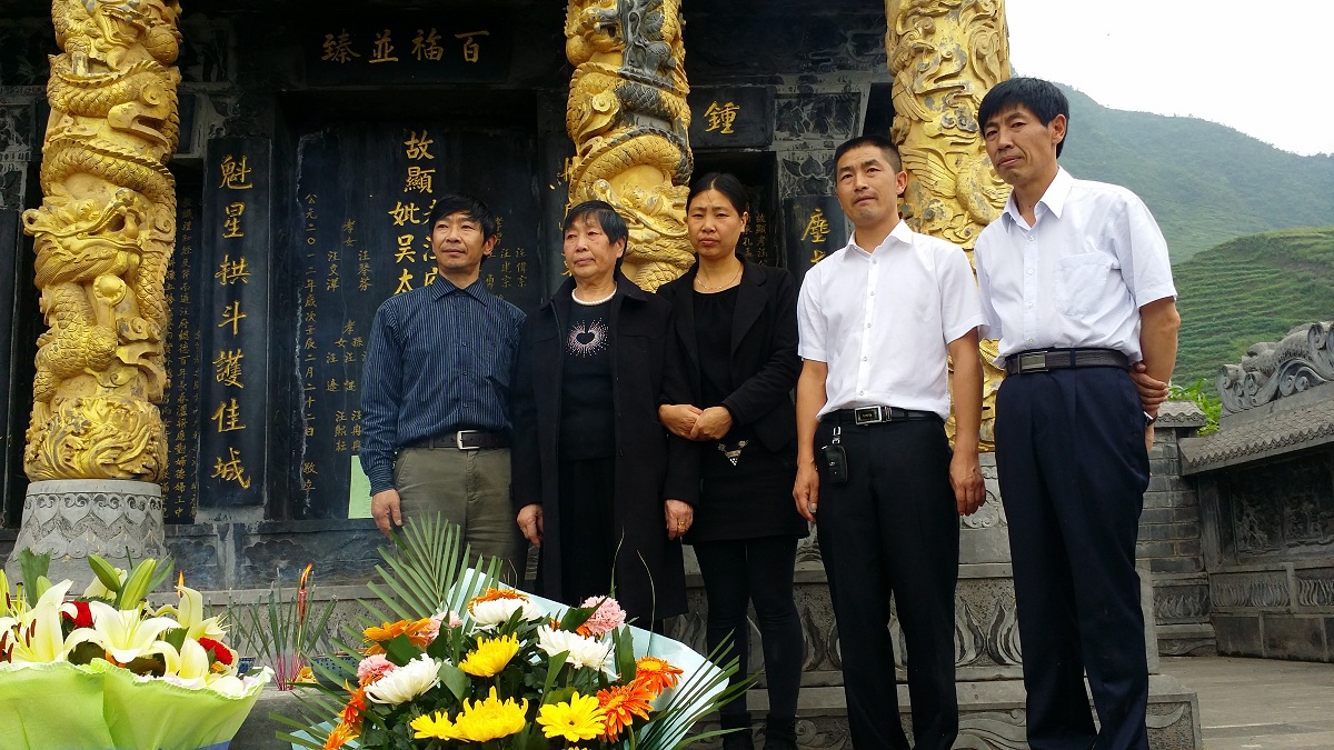 在父亲的坟墓前留影