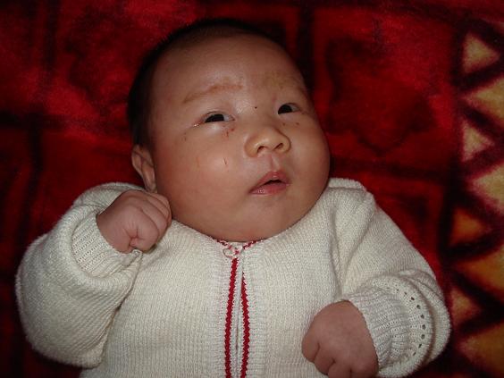 今天儿子满月了，庆贺一下。晚上请人喝满月酒，回家十点了，宝宝已经入睡了，为了拍满月照，只有把他弄醒，