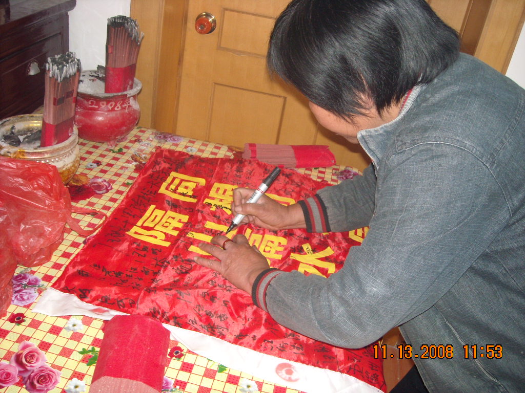 在锦旗上签字，以保佑来年添一个大胖孙子