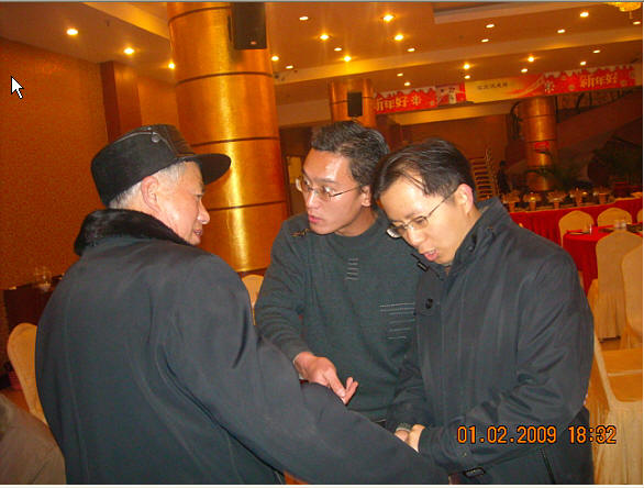 在宴会场边汪海先生与振亮握手言欢