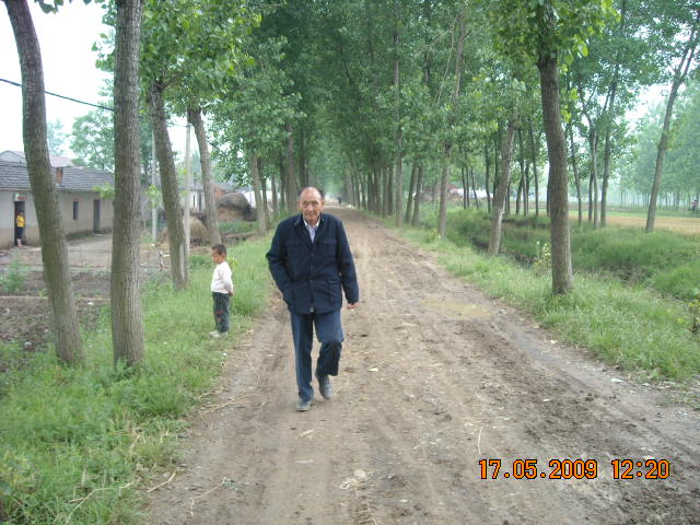 老人今年84岁很精神走在乡间小道上