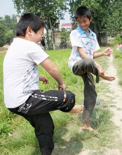 5月28日，汪舒生（(右一）与同学汪光荣在村口玩游戏“对车”。（