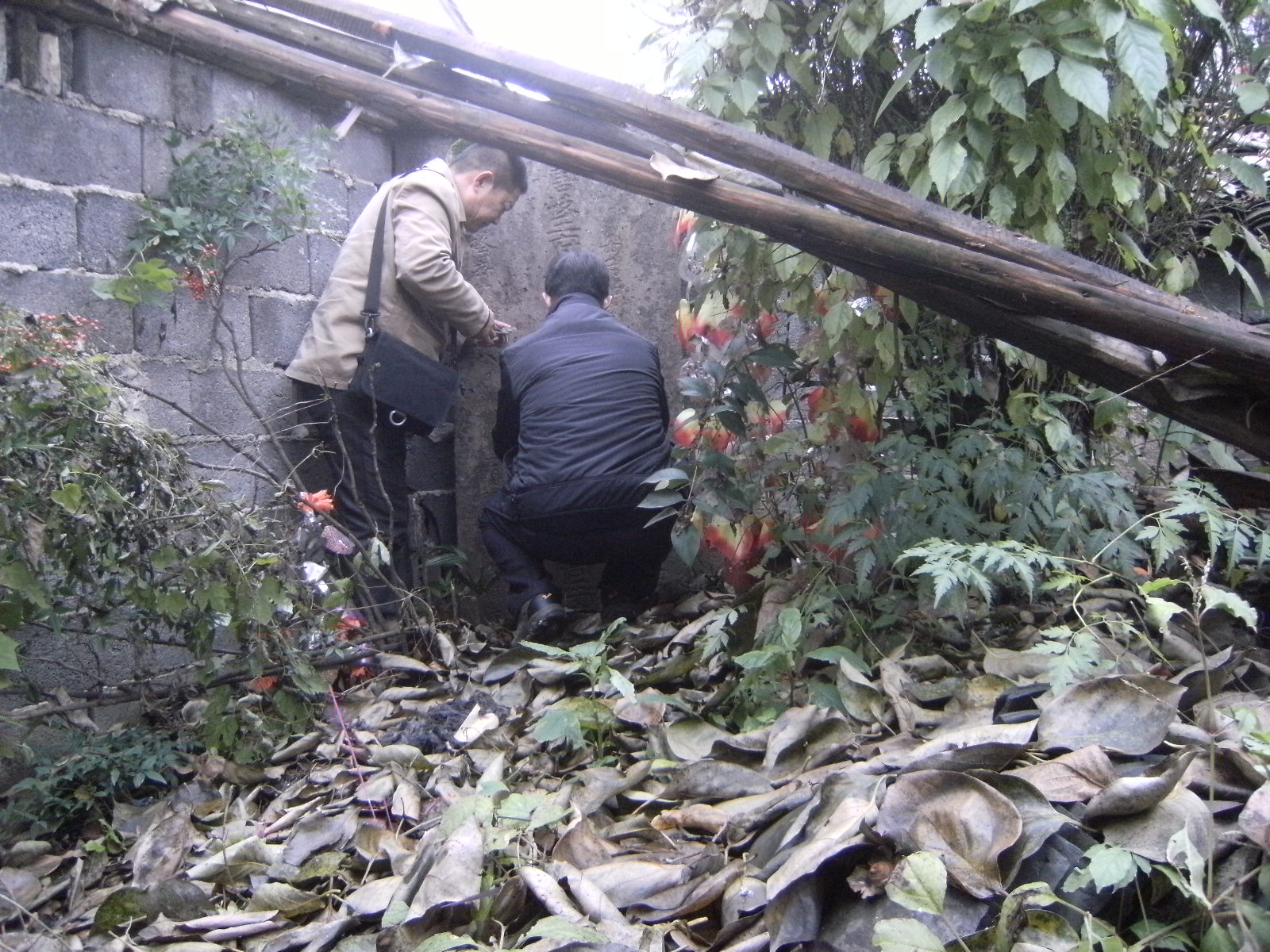 坟上堆有许多旧木料和瓦片