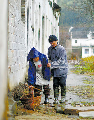 汪岩林独臂搀扶着妻子，相濡以沫，笑对人生。